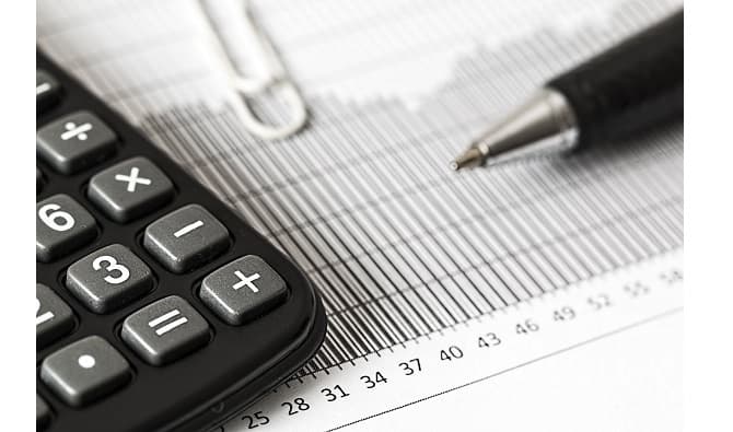 A calculator and pen on a financial report